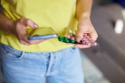 Une femme lit la notice d'un médicament sur smartphone