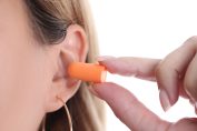 Une femme insère des bouchons d’oreille