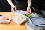 Un homme range des aliments frais dans des boites