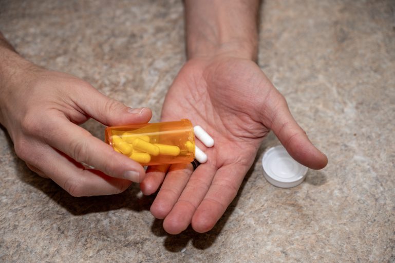Gros plan sur les mains avec un flacon de pilules