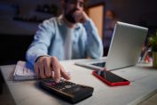 Un homme fait ses comptes avec une calculette