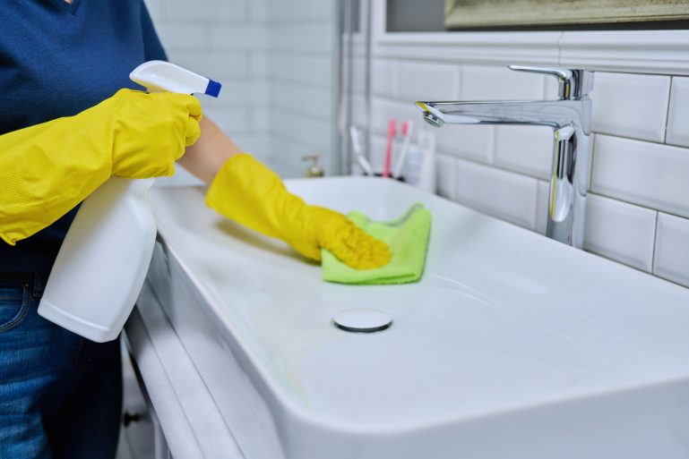 Nettoyage d'un lavabo avec un spray nettoyant