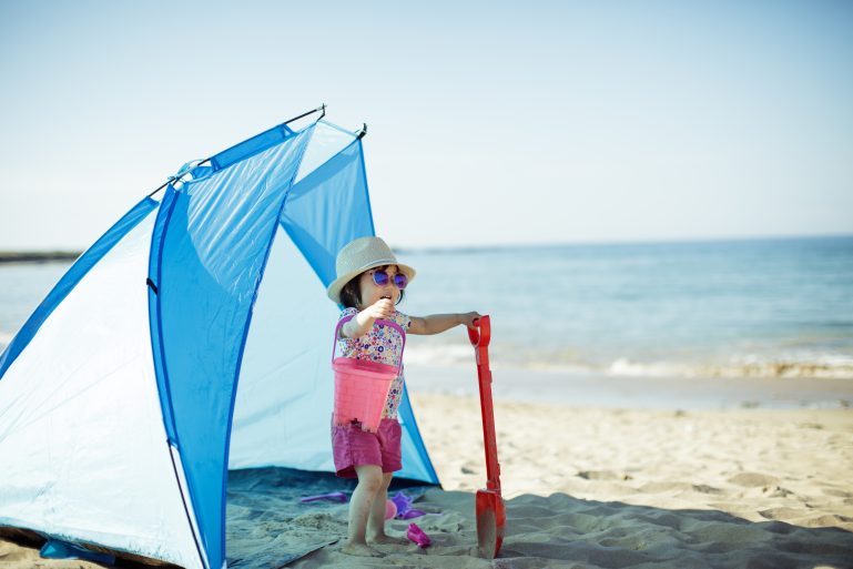 Petite fille jouant sur la plage d’été