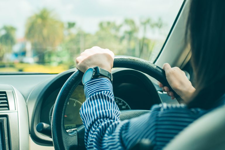 Le conducteur d'une voiture les mains sur le volant