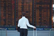 Un passager regarde les vols sur un panneau d'affichage
