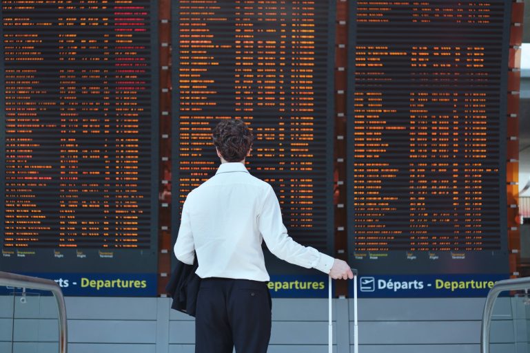 Un passager regarde les vols sur un panneau d'affichage