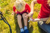 Une mère soigne le genou d'un enfant