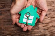 Une main tient une maison et une clé