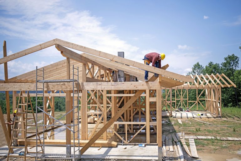 Charpentier travaillant sur le toit d’une maison en bois