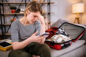 Une jeune femme stressée devant une valise