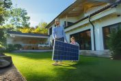 Un père et sa fille portent un panneau photovoltaïque