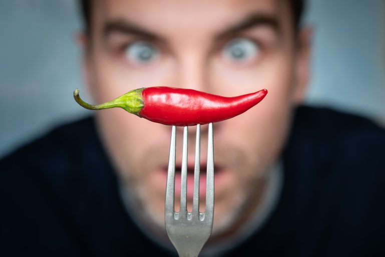 Un homme effrayé à l'idée de manger un piment