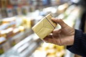 Une plaquette de beurre entre les mains d'un consommateur