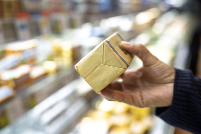 Une plaquette de beurre entre les mains d'un consommateur