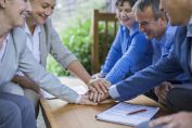 Des personnes empilent leurs mains sur une table