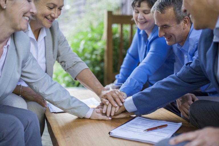 Des personnes empilent leurs mains sur une table