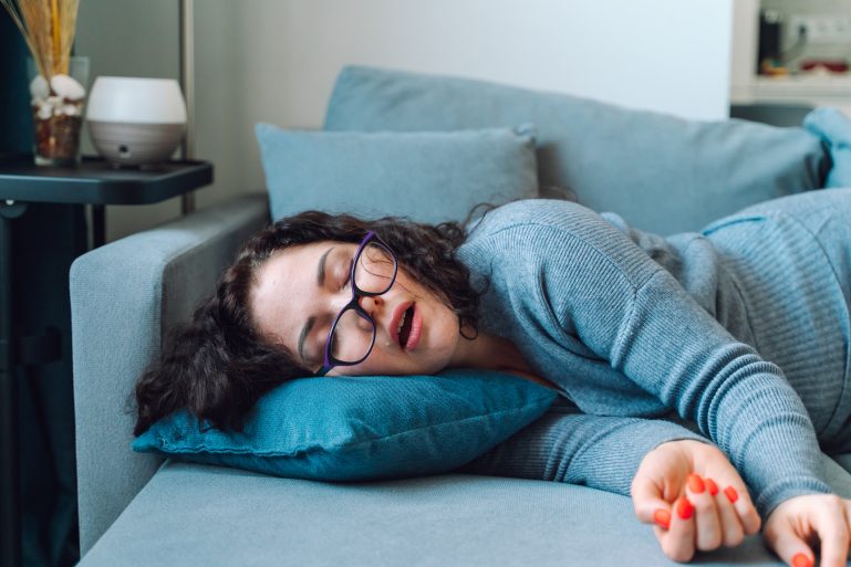 Une femme dort sur un sofa