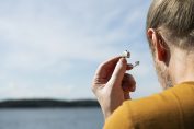 Un homme enlève son appareil auditif
