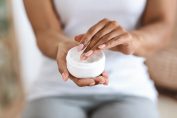 Une femme noire se met de la crème