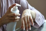 Une femme se met de la crème après une poussée d'eczéma