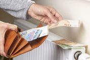Une femme pose des billets sur un radiateur