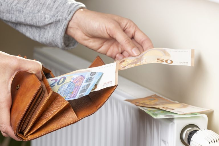 Une femme pose des billets sur un radiateur