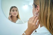 Une femme regarde ses boucles d'oreille