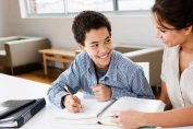 Une jeune femme aide un garçon à faire ses devoirs
