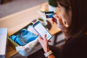Une jeune femme achète des articles avec son smartphone