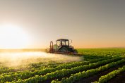 Un tracteur pulvérise des pesticides dans un champ