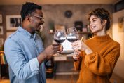 Un homme et une femme trinquent avec un verre de vin