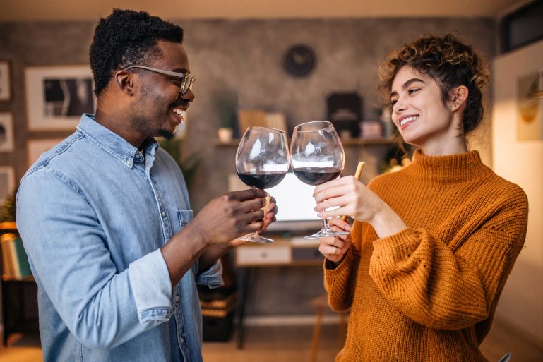 Un homme et une femme trinquent avec un verre de vin