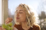 Une jeune femme mange du raisin