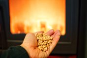 Une main tenant des pellets devant un poêle