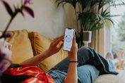 Une jeune femme règle son chauffage sur son smartphone