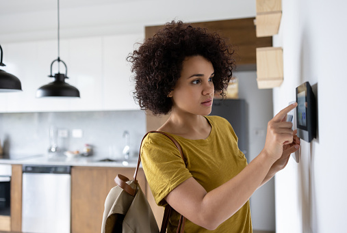 Femme quittant sa maison et activant l’alarme