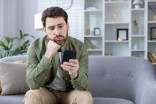Un homme boude en regardant son téléphone