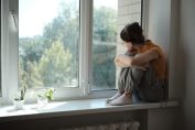 Une jeune fille se tient près d'une fenêtre