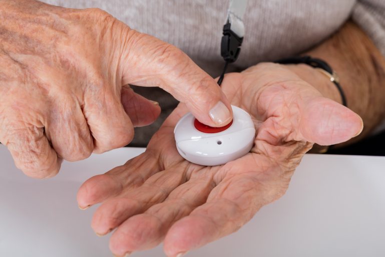 Une alarme de téléassistance dans une main
