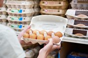 Une consommatrice achète des œufs dans un supermarché