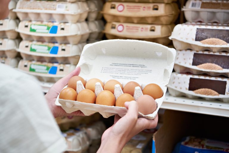Une consommatrice achète des œufs dans un supermarché