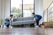 Un couple déménage un canapé