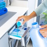 Un homme met de la lessive dans sa machine à laver