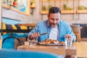 Un homme déguste une pizza