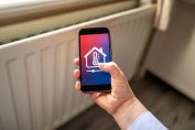 Une appli de thermostat connecté devant un radiateur