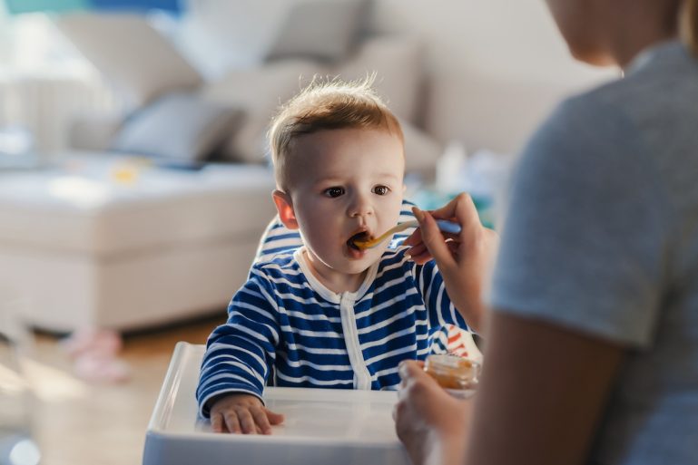 Une femme donne un petit pot à un enfant