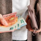Une femme sort des billets de son porte-monnaie
