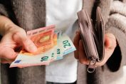 Une femme sort des billets de son porte-monnaie