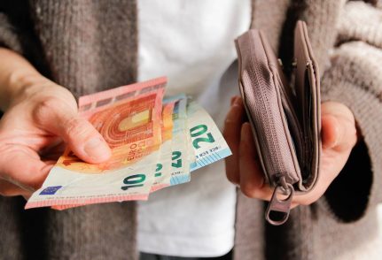 Une femme sort des billets de son porte-monnaie
