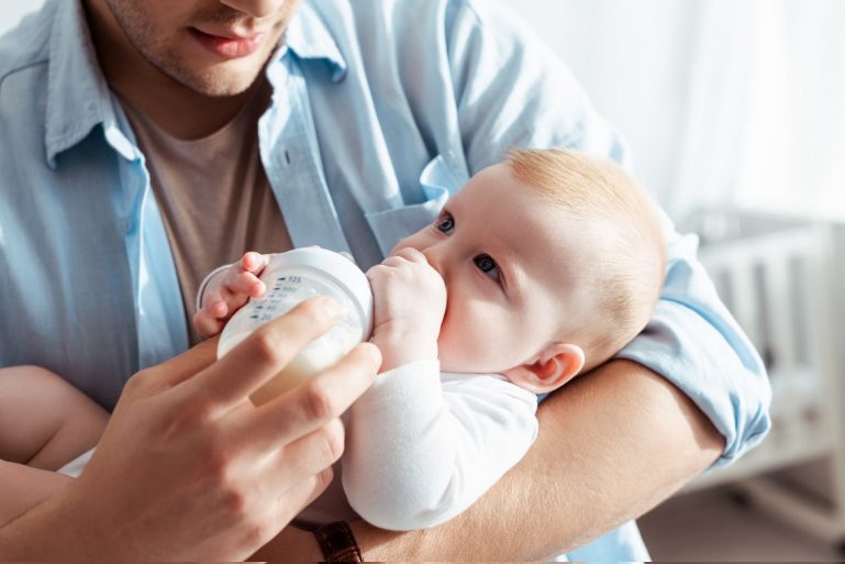 Un papa donne le biberon à son bébé
